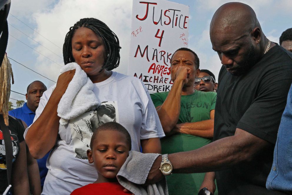   PHOTO: Michael McGlockton, Markeis McGlockton's father, wipes the face of Markeis's grandson and son Markeis McGlockton Jr. as protesters gather to express their concerns in Clearwater Fla on July 22nd. 2018. 