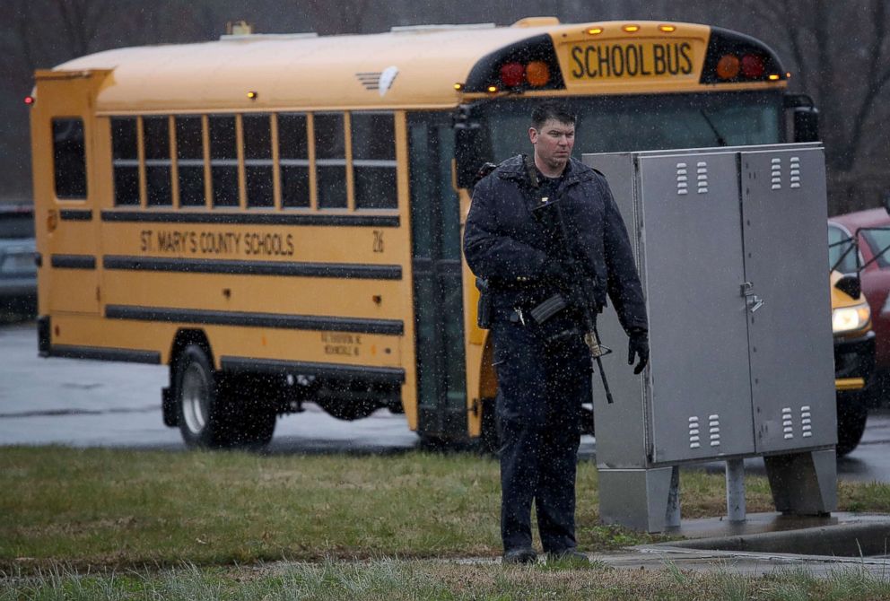 PHOTO: A heavily armed law enforcement officer stands guard as students from Great Mills High School are evacuated to Leonardtown High School following a school shooting at Great Mills High School, March 20, 2018. 