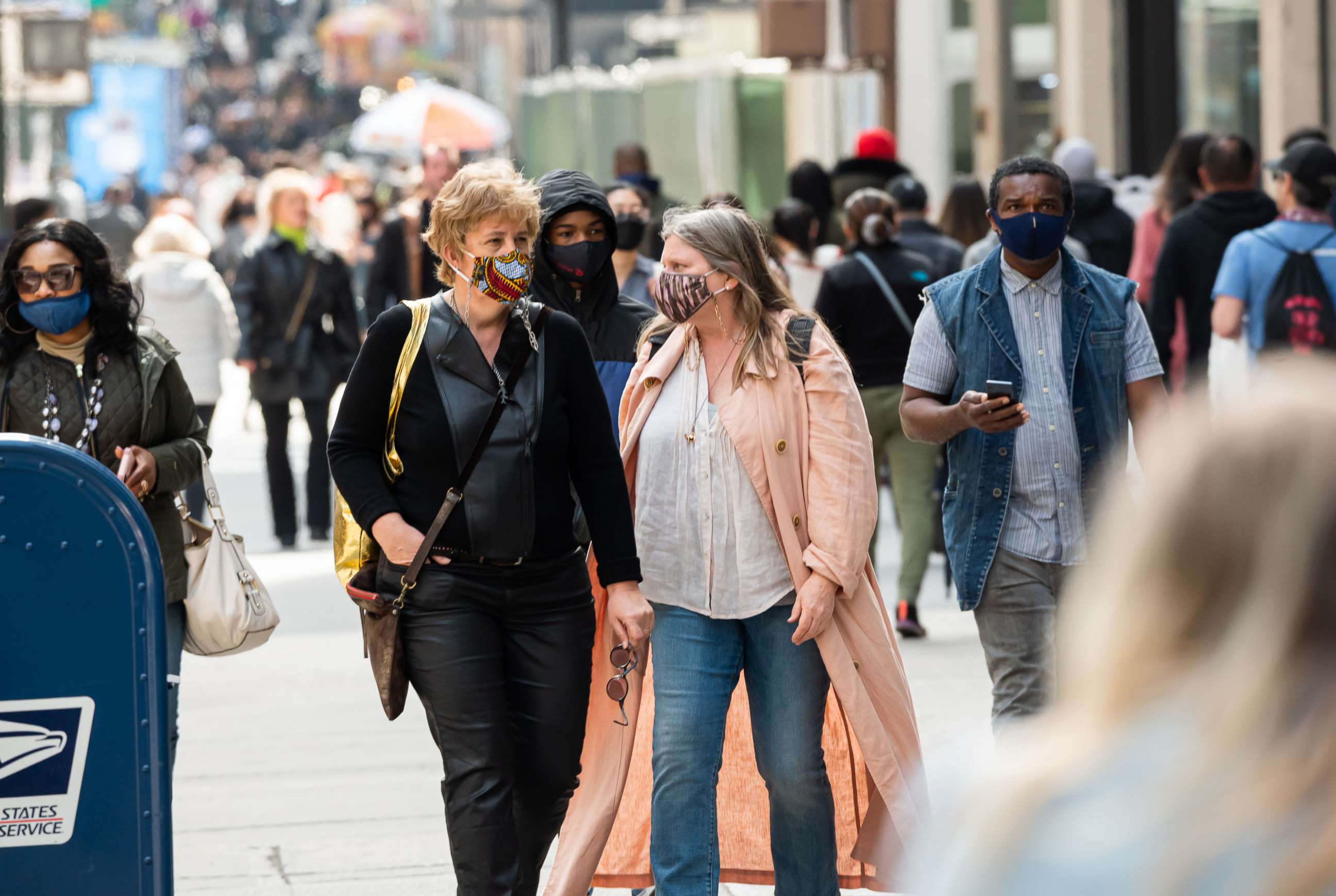 PHOTO: People wear face masks while walking on Fifth Avenue, April 10, 2021, in New York.