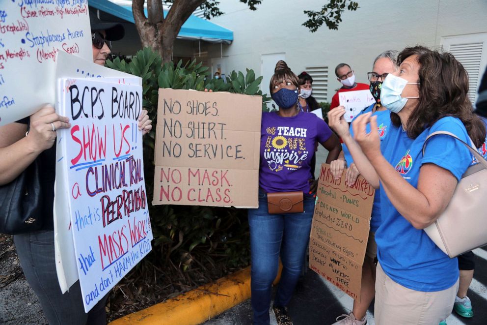 PHOTO: In this Aug. 10, 2021, file photo, teachers try to persuade an anti-mask protester that all students need to wear masks to protect the most vulnerable. during a protest outside of a Broward County School Board meeting in Fort Lauderdale, Fla.