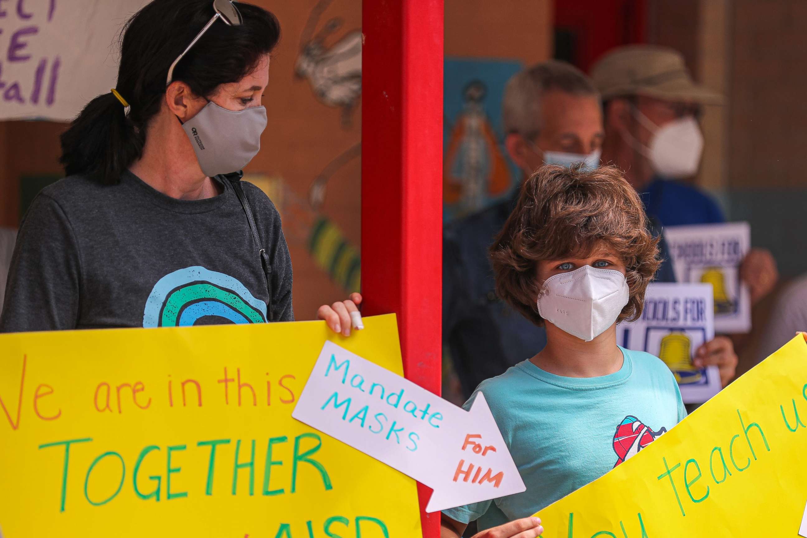 PHOTO: Milana Noueilaty stands with her son, Kaden, holding signs in support of mask mandates on Aug. 9, 2021.