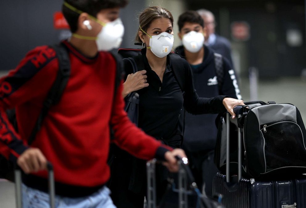 PHOTO: Passengers wearing masks arrive at Dulles International Airport March 13, 2020, in Dulles, Virginia.