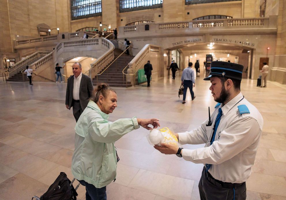 PHOTO: Metro North railroad employee Jommy Mosquera hands out free N95 masks to people passing through Grand Central Terminal as smoke from wildfires burning in Canada continues to create unhealthy conditions in New York, June 8, 2023.