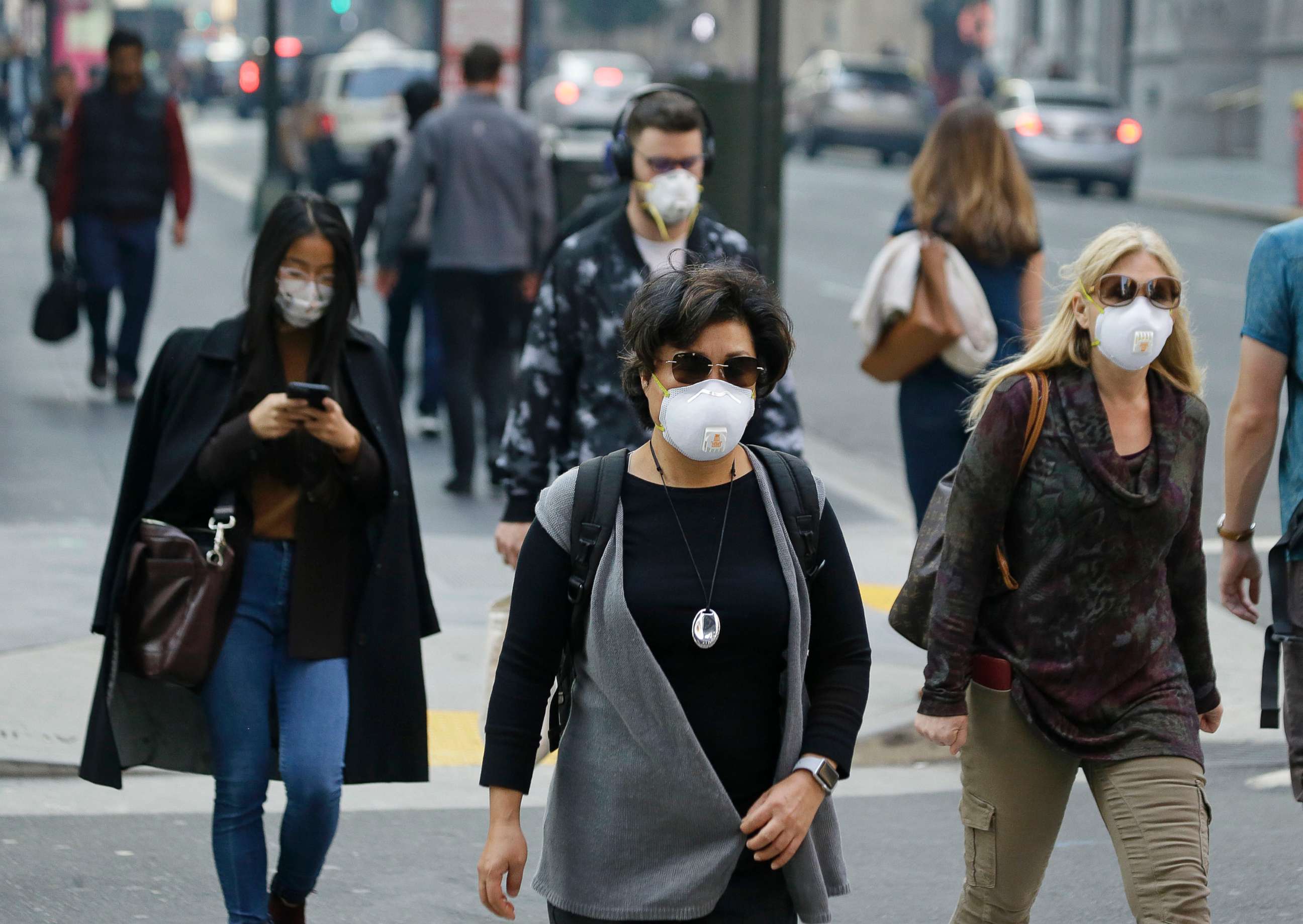 PHOTO: People wear masks while walking through the Financial District in the smoke-filled air, Nov. 9, 2018, in San Francisco. Authorities have issued an unhealthy air quality alert for parts of the San Francisco Bay Area due to the wildfires.