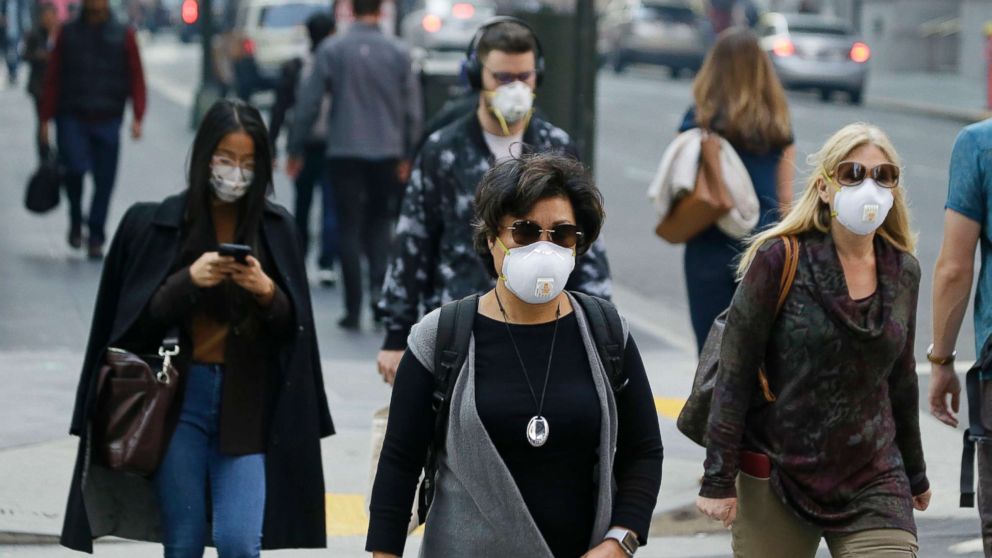 PHOTO: People wear masks while walking through the Financial District in the smoke-filled air, Nov. 9, 2018, in San Francisco. Authorities have issued an unhealthy air quality alert for parts of the San Francisco Bay Area due to the wildfires.