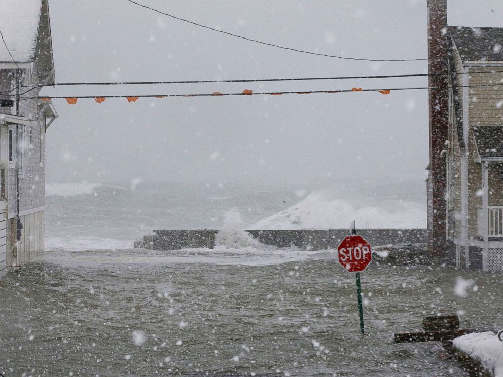 FOTO: A água corre sobre o paredão entre duas casas, em 4 de janeiro de 2018, em Scituate, Massachusetts. 