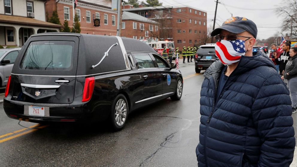 PHOTO: Townspeople line the streetnas the hearse carrying veteran Mary Foley, who could not have a full military funeral because of restrictions due to the coronavirus outbreak, passes by in Arlington, Mass., April 8, 2020.