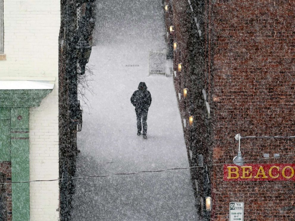 PHOTO: A man walks down an alley to McKay Street as snow falls in Pittsfield, Mass., Feb, 12, 2019.