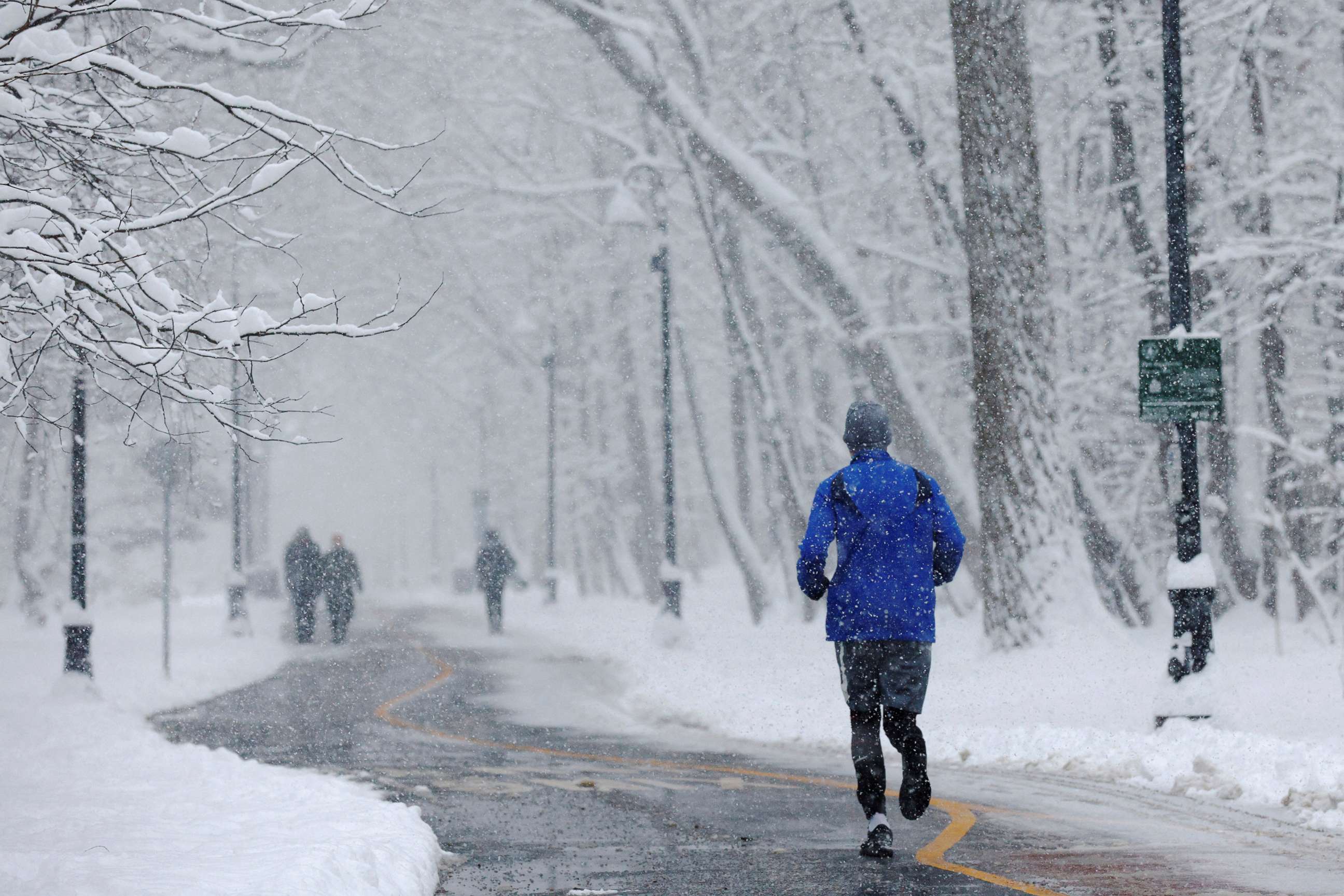 PHOTO: A jogger runs through the falling snow in Somerville, Mass., Jan. 7, 2022. 