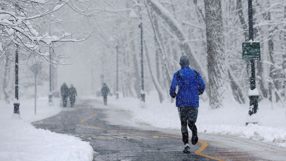 PHOTO: A jogger runs through the falling snow in Somerville, Mass., Jan. 7, 2022. 