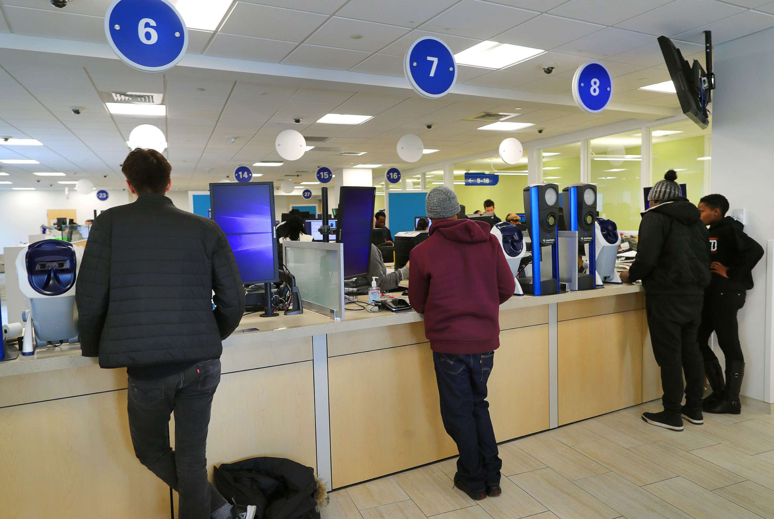 PHOTO: Customers wait to get their drivers licenses at a counter in the Haymarket Registry of Motor Vehicles office in Boston on March 21, 2018.