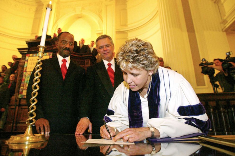 PHOTO: David Wilson, left, and Robert Compton are joined at Arlington Street Church by the Rev. Kim Crawford Harvie while signing the marriage license, May 17, 2004.