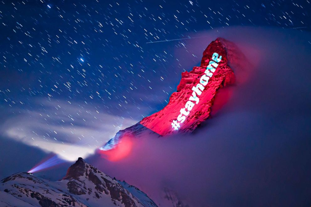 PHOTO: The iconic Matterhorn mountain is illuminated by Swiss light artist Gerry Hofstetter with messages of hope, support and solidarity during the global coronavirus pandemic, March 26, 2020, in the alpine resort of Zermatt, Switzerland.