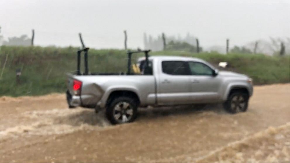 PHOTO: This still image taken from social media video shows a vehicle traveling through a flooded street near the Kaupakalua Dam in the town of Haiku on Maui, Hawaii, on March 8, 2021.