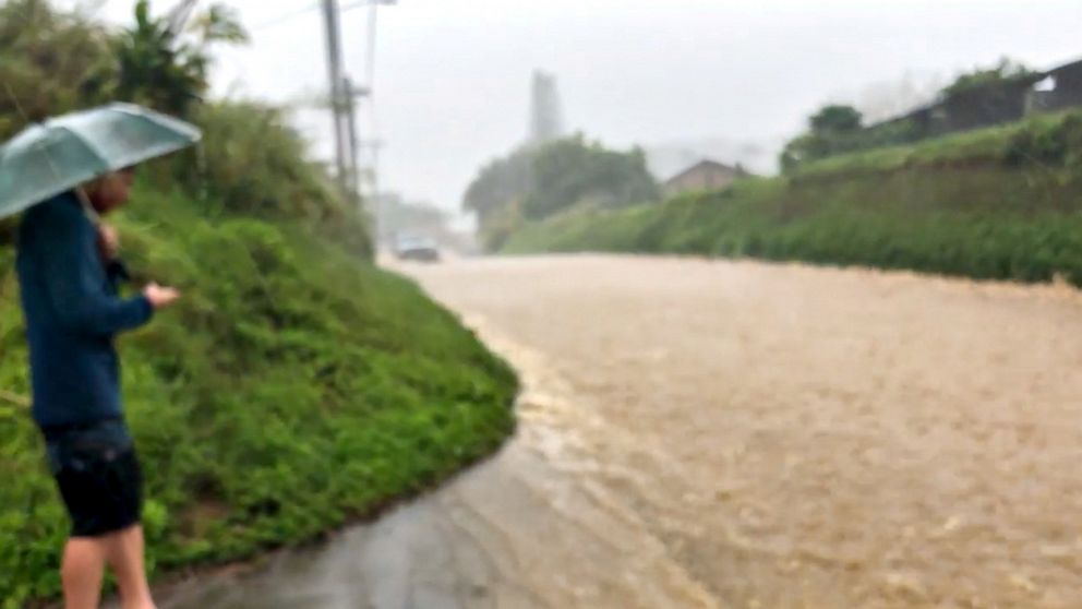 PHOTO: This still image taken from social media shows a man looking at a flooded street near the Kaupakalua Dam in the town of Haiku on Maui, Hawaii, on March 8, 2021.
