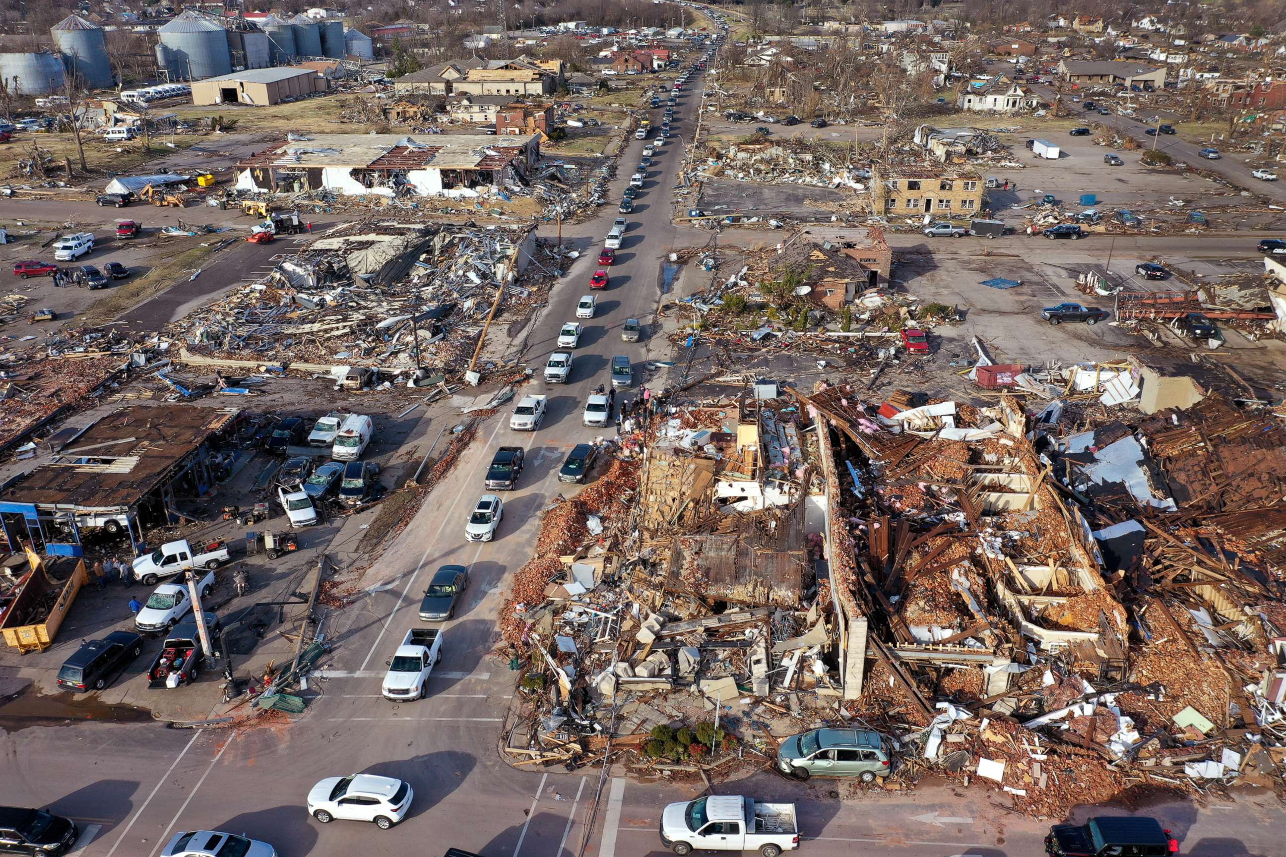 PHOTO: Cars drive though the remains of homes and businesses destroyed after a tornado ripped through town the previous evening, Dec. 11, 2021 in Mayfield, Ky.