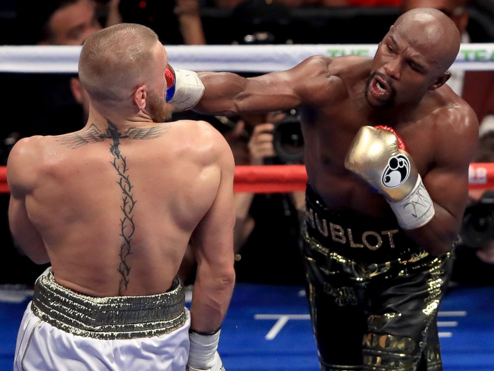 PHOTO: Floyd Mayweather Jr. throws a punch at Conor McGregor during their super welterweight boxing match on August 26, 2017 at T-Mobile Arena in Las Vegas, Nevada.