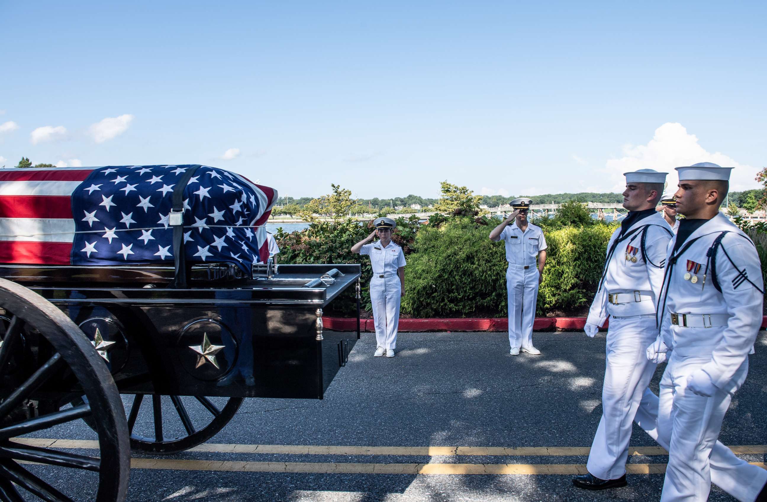 Midshipmen salute the late Sen. John McCain as a horse-drawn caisson transports his flag-draped casket to the United States Naval Academy Cemetery for his burial service, Sept. 2, 2018. 
