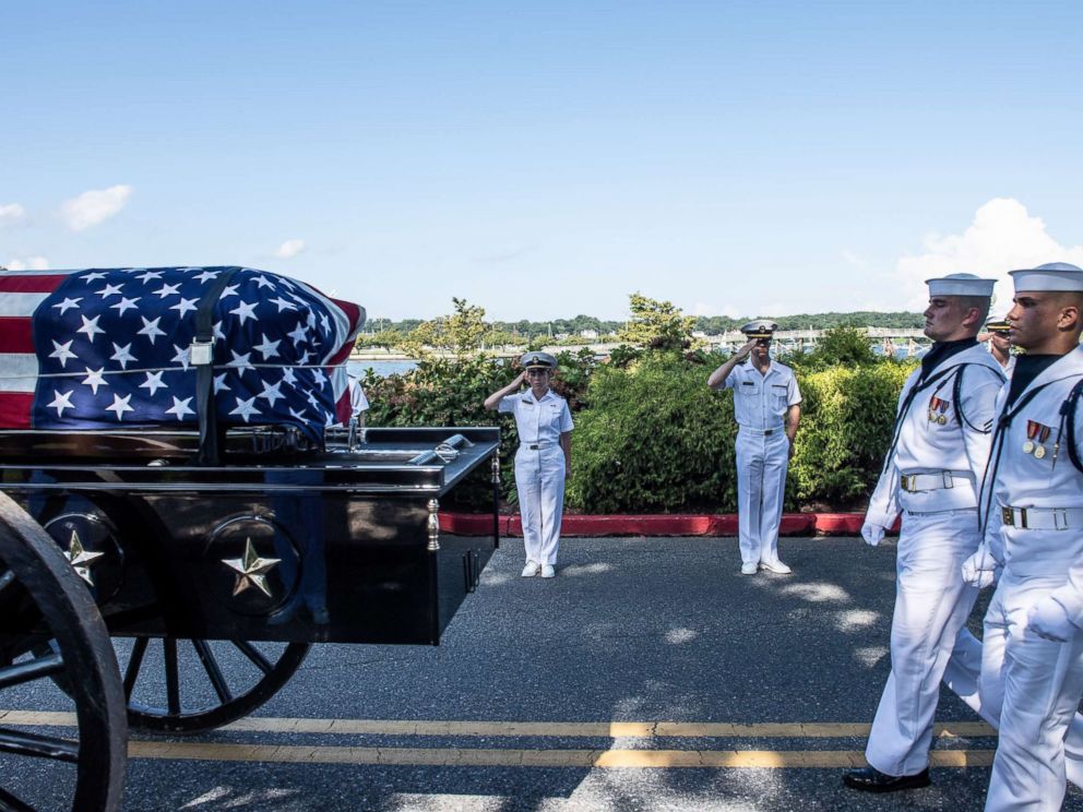 Midshipmen salute the late Sen. John McCain as a horse-drawn caisson transports his flag-draped casket to the United States Naval Academy Cemetery for his burial service, Sept. 2, 2018.