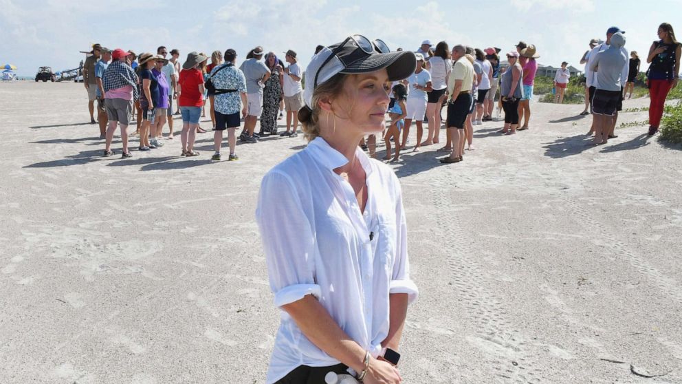 PHOTO: Stephanie Young McCluney, wife of Brian McCluney, one of two missing boaters, is joined by supporters at Jetty Park, Aug. 18, 2019, to pray and search the shore clues to the missing boaters who left Port Canaveral two days earlier.