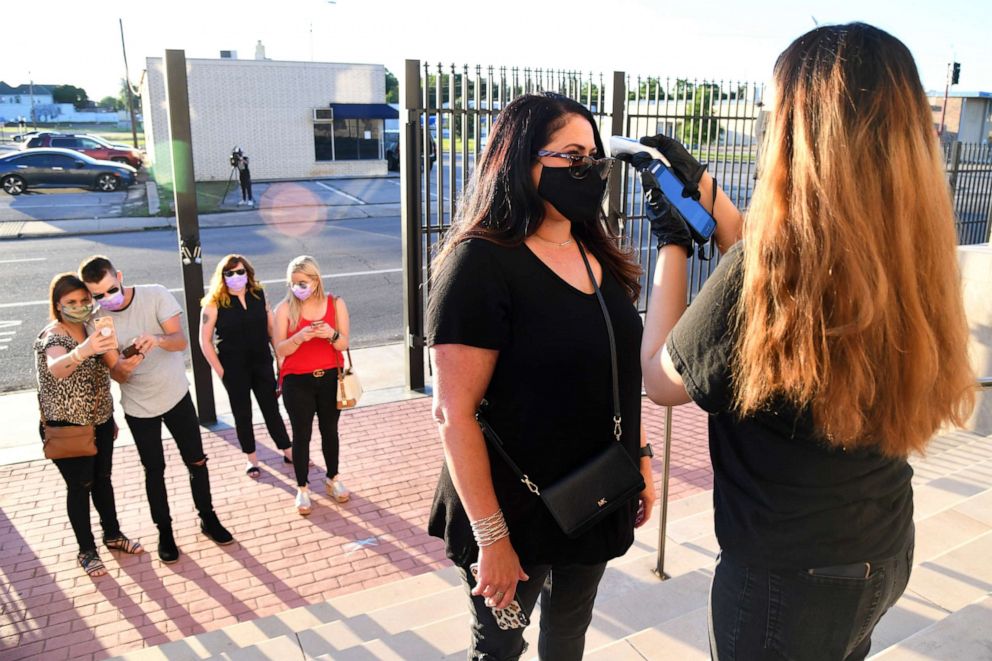 PHOTO: A concert goer has her temperature taken prior to entering the first socially-distanced concert at TempleLive in on May 18, 2020 in Fort Smith, Arkansas.