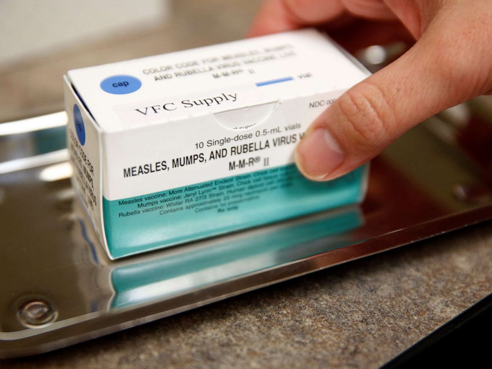 PHOTO: Lead medical assistant Fengmei Lin holds a box of measles, mumps, and rubella (MMR) vaccine vials at the International Community Health Services clinic in Seattle, March 20, 2019.