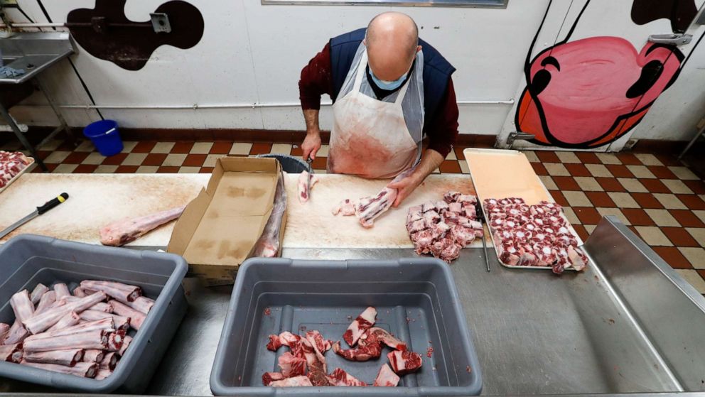 PHOTO: John Warminski butchers ox tail at Ronnie's Quality Meats in Detroit, Wednesday, April 29, 2020.
