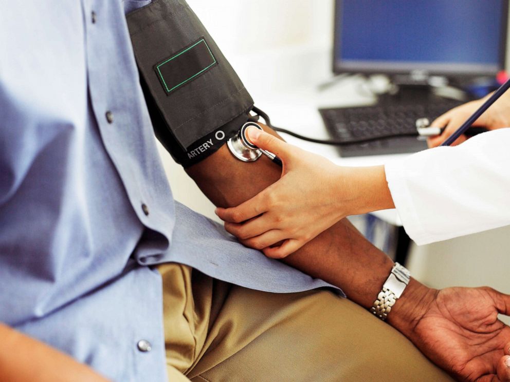 PHOTO: An African-American patient has his blood pressure taken by a female doctor in an undated stock image.