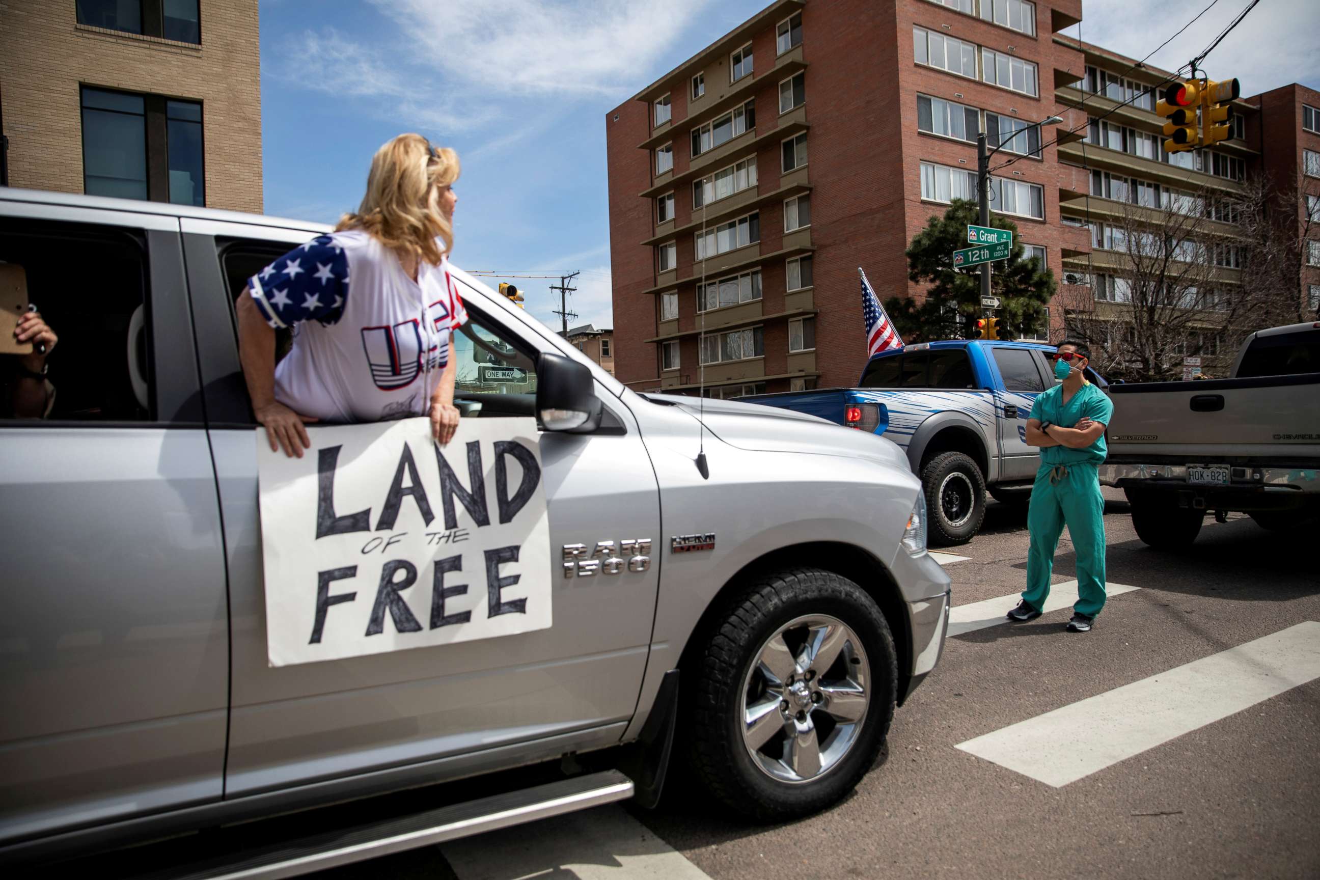 PHOTO: A health care worker stands in the street in counter-protest to hundreds of people who gathered at the Colorado State Capitol to demand the stay-at-home order be lifted in Denver, April 19, 2020.