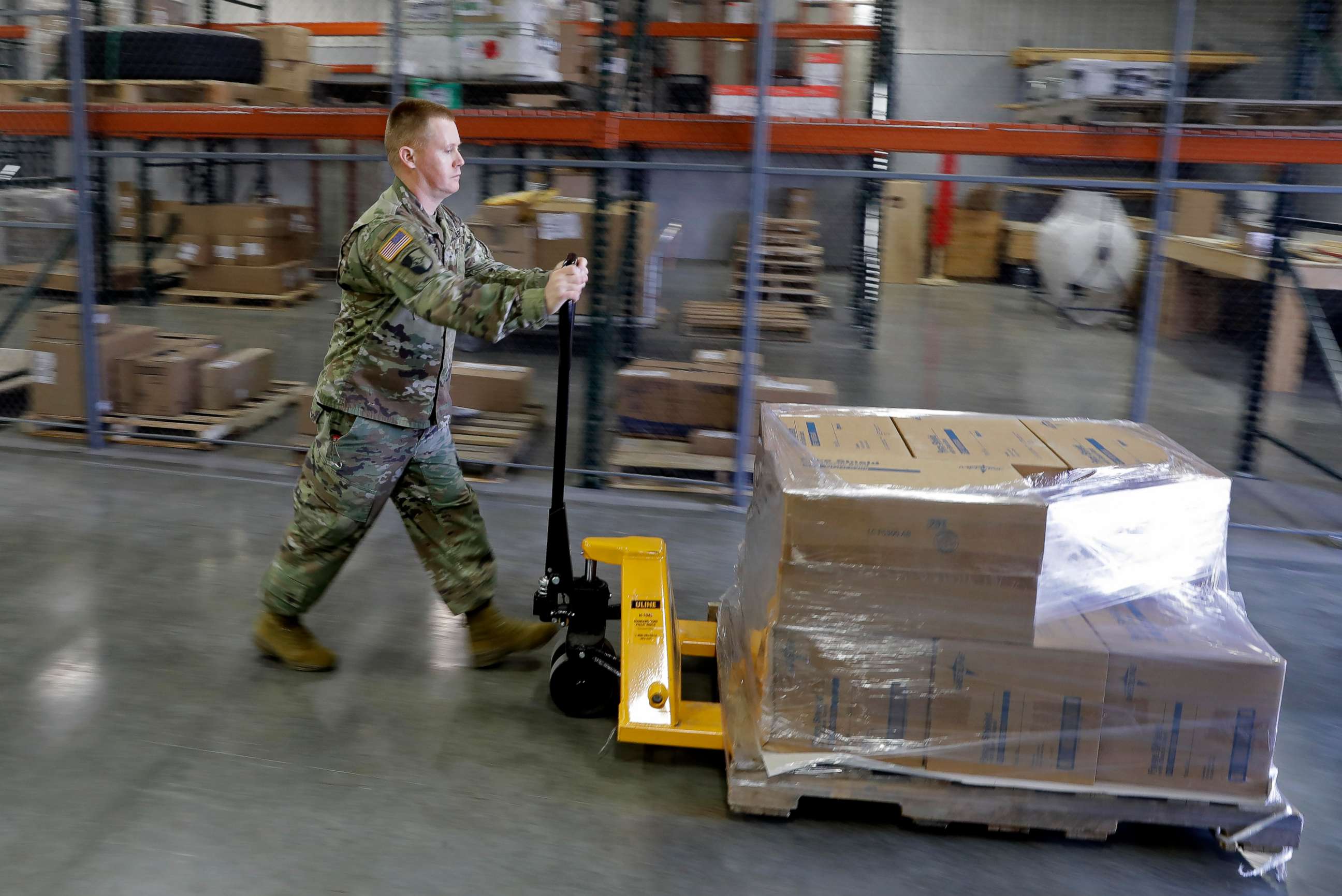 PHOTO: A Indiana National Guardsman pushes a pallet of medical supplies to be delivered, March 26, 2020, in Indianapolis. 