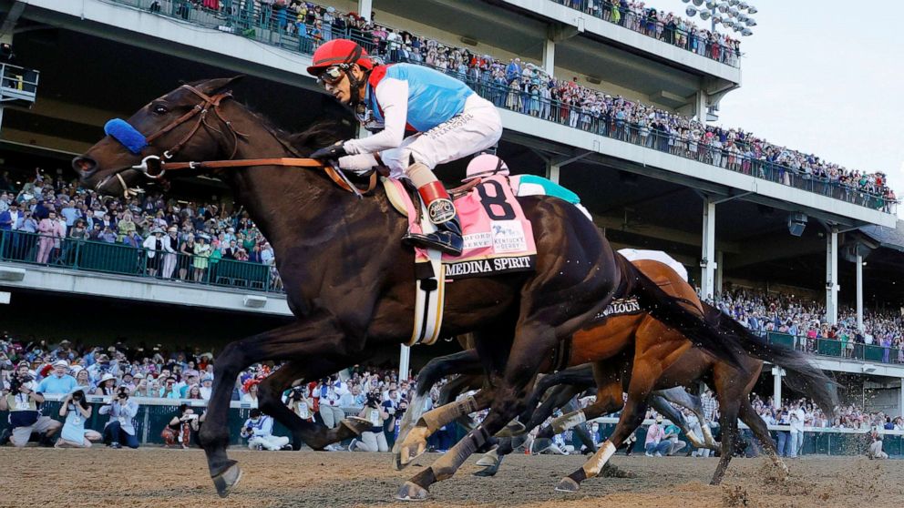 PHOTO: Medina Spirit #8, ridden by jockey John Velazquez, (R) crosses the finish line to win the 147th running of the Kentucky Derby at Churchill Downs, May 1, 2021, in Louisville, Kentucky.