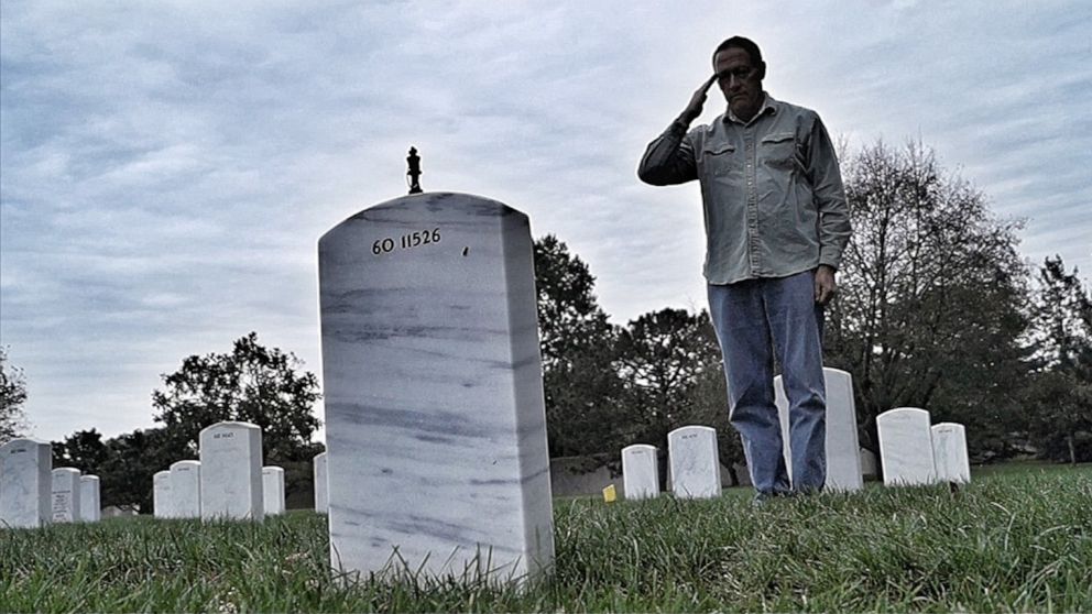 PHOTO: After placing a chess piece on his headstone, Henry Black salutes his son, Army Staff Sgt. Bryan Black, who was killed in Tongo Tongo, Niger, in 2017.