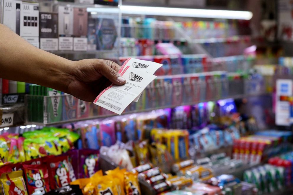 PHOTO: FILE - A man holds Mega Millions lottery tickets, July 29, 2022 in New York City.