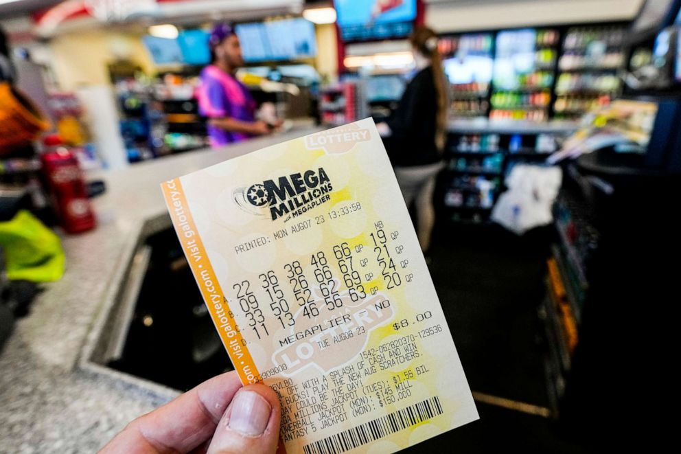 PHOTO: A Mega Millions ticket is seen as a person makes a purchase inside a convenience store, ahead of Tuesday's Mega Millions drawing of $1.55 billion, Monday, Aug. 7, 2023, in Kennesaw, Ga.