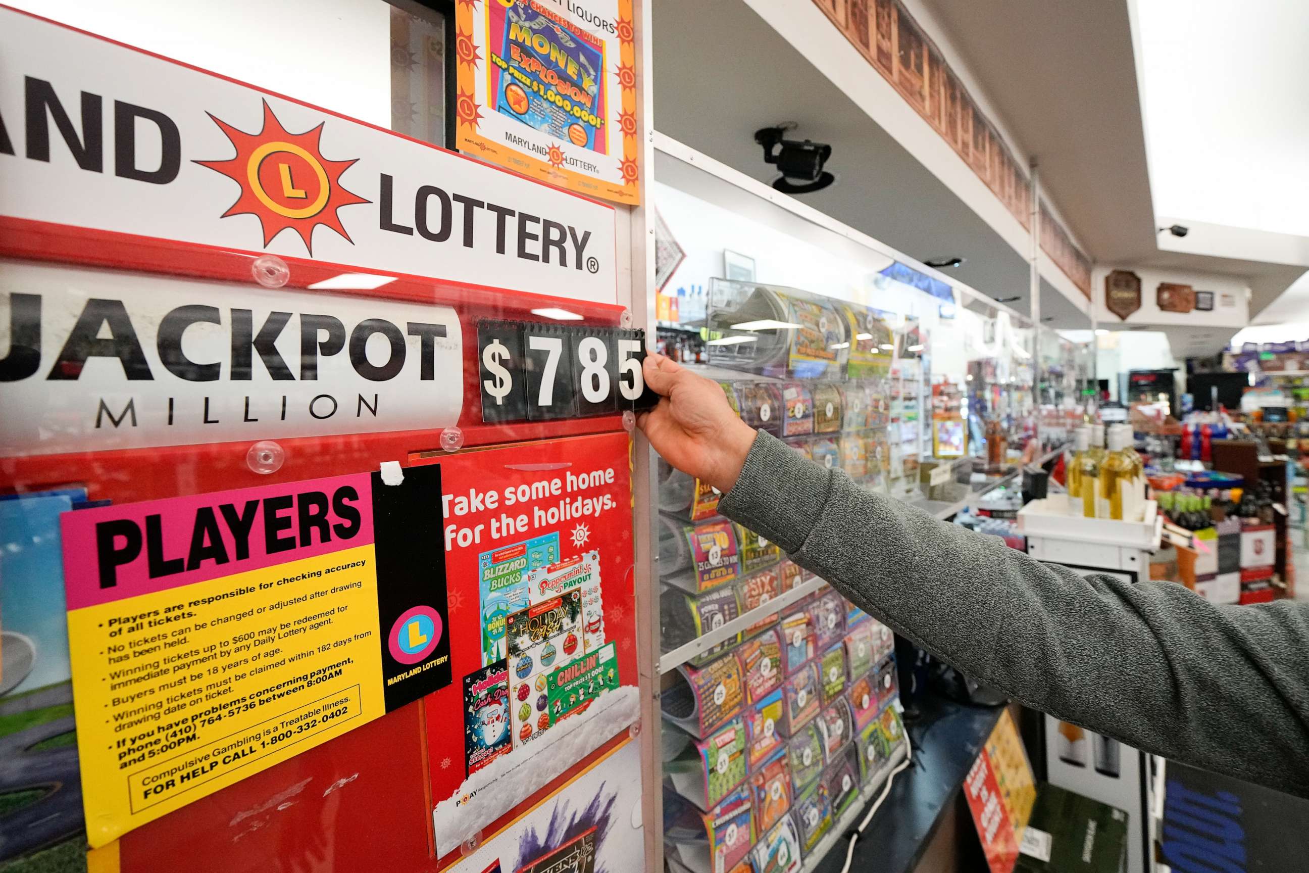 PHOTO: A clerk at Broad Street Liquors updates the Mega Millions jackpot at the store's lottery counter, Tuesday, Jan. 3, 2023, in Timonium, Md.