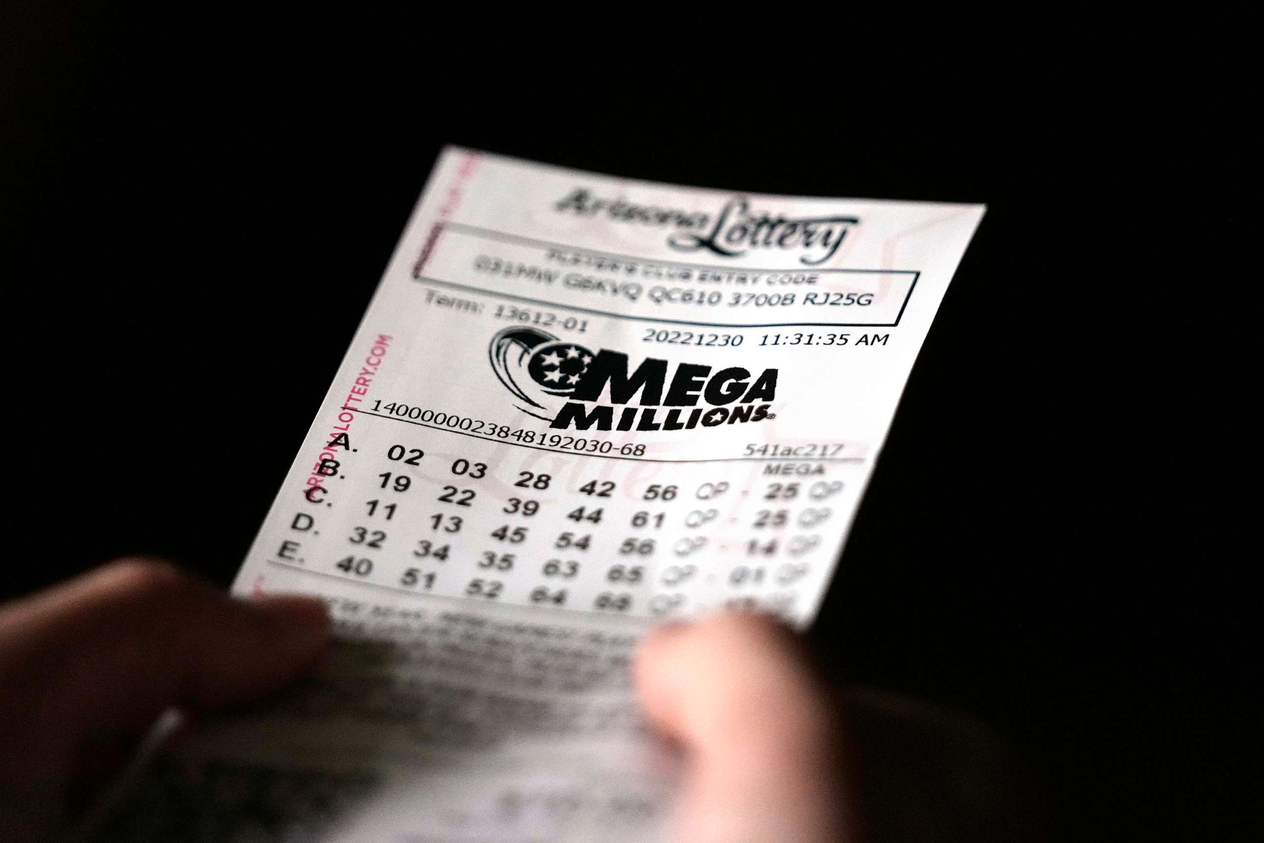 PHOTO: A person holds a Mega Millions lottery ticket in Tempe, Ariz., on Dec. 30, 2022.