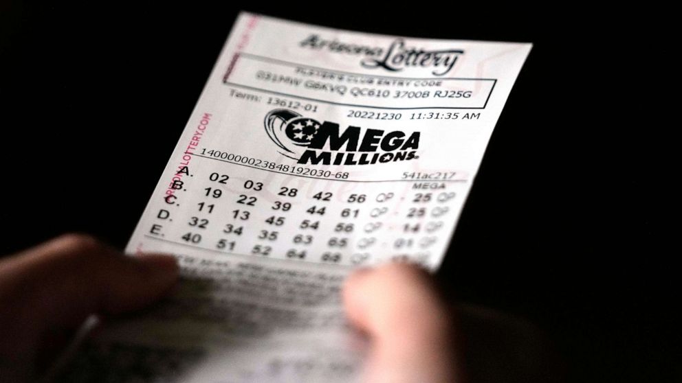 PHOTO: A person holds a Mega Millions lottery ticket in Tempe, Ariz., on Dec. 30, 2022.