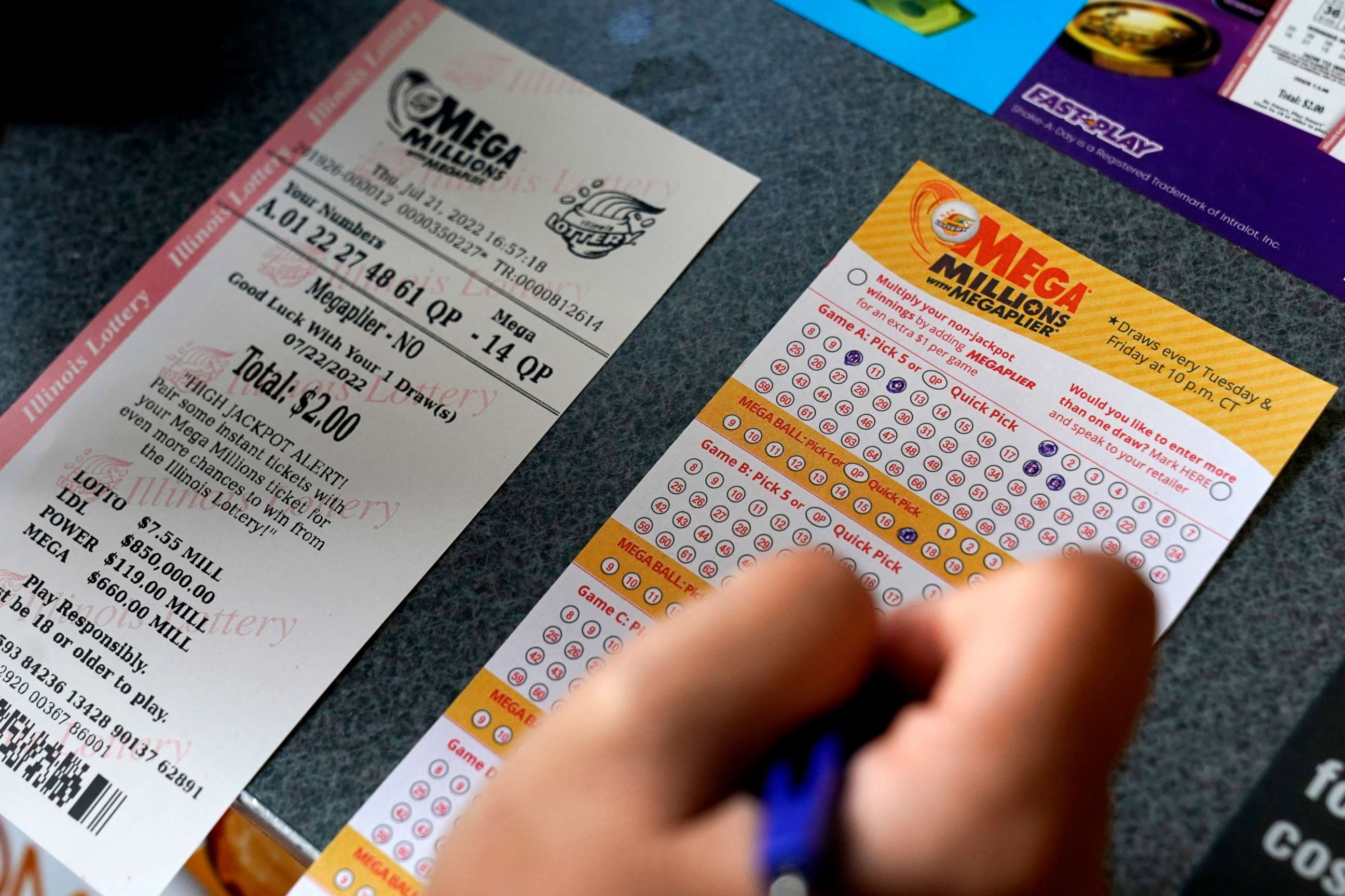 PHOTO: A customer fills out a Mega Millions lottery ticket at a convenience store, July 21, 2022, in Northbrook, Ill.