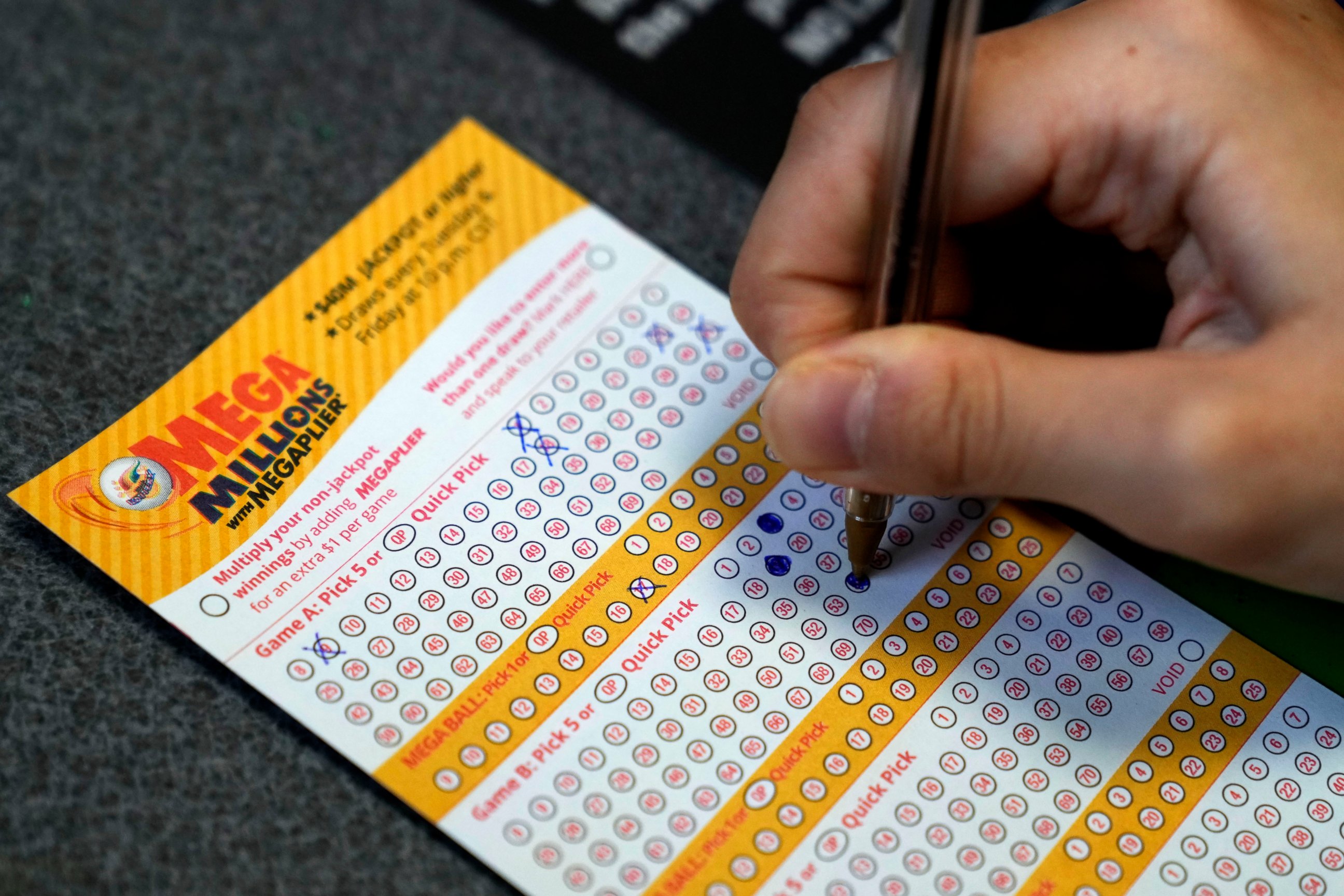 PHOTO: A customer fills out a Mega Millions lottery ticket at a convenience store Tuesday, Jan. 3, 2023, in Northbrook, Ill.