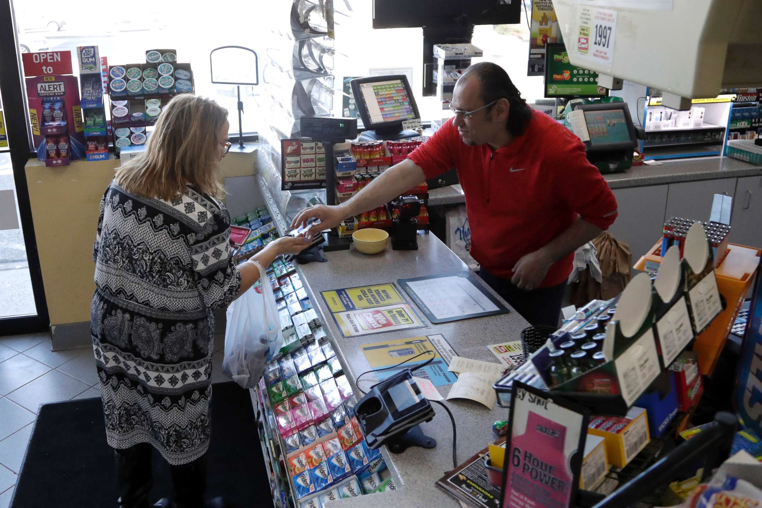 PHOTO: A cashier checks out a customer at a Lukoil service station where the winning ticket for the Mega Millions lottery drawing was sold, March 31, 2018, in Riverdale, N.J. 