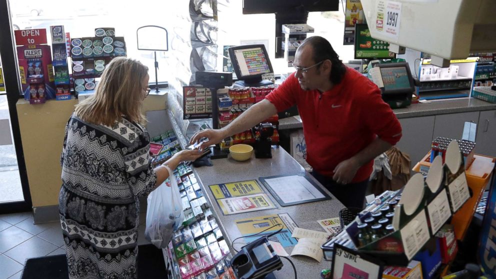 PHOTO: A cashier checks out a customer at a Lukoil service station where the winning ticket for the Mega Millions lottery drawing was sold, March 31, 2018, in Riverdale, N.J. 
