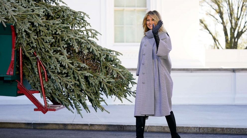 PHOTO: First lady Melania Trump waves as she stands next to the 2020 Official White House Christmas tree as it is presented on the North Portico of the White House, Nov. 23, 2020, in Washington.