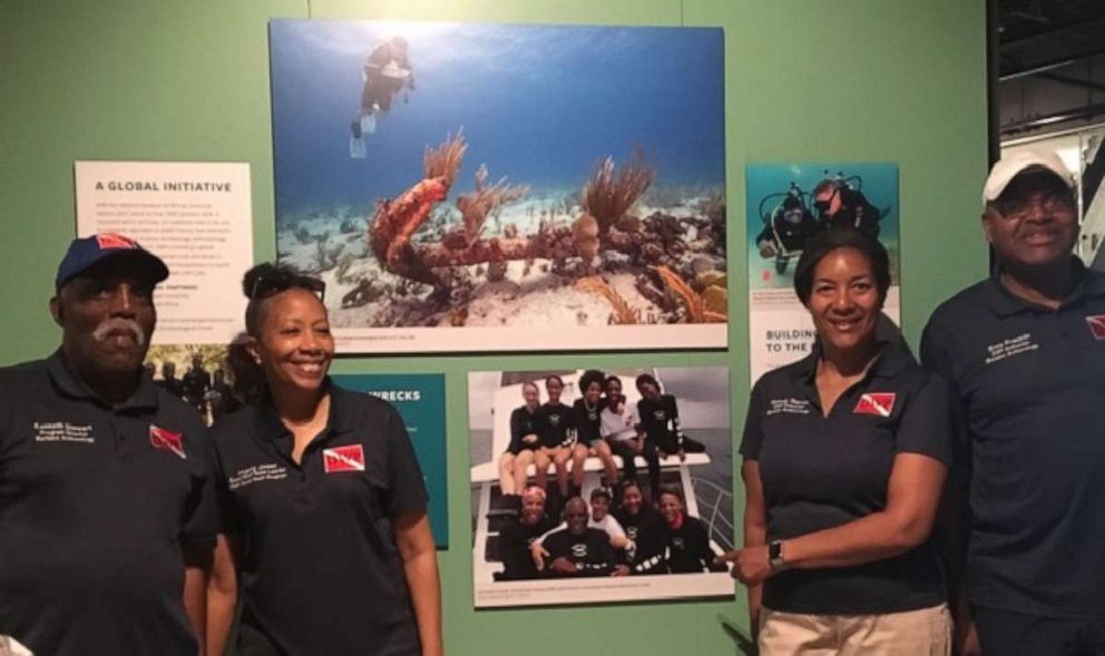 PHOTO: From left, DWP divers Ken Stewart, Angela Jones, Melody Garrett and Ernie Franklin with their picture in the National Museum of African American History and Culture.