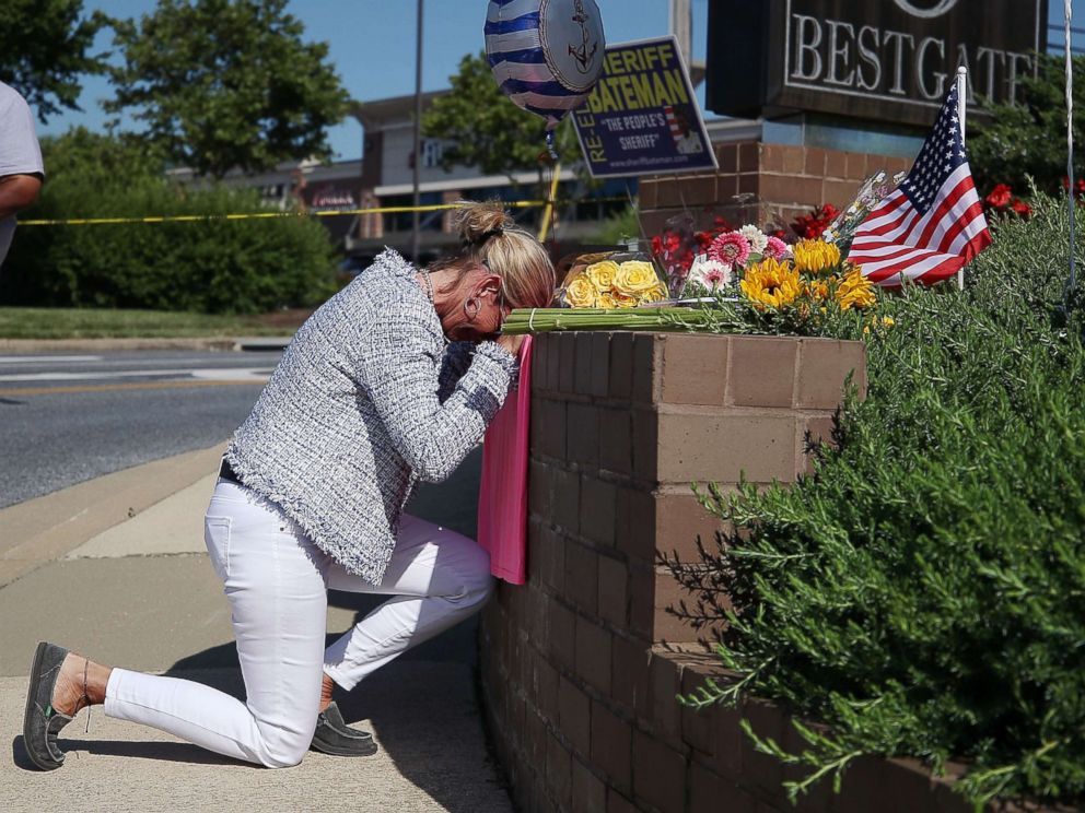 PHOTO: Lynne Griffin pays her respects at a makeshift memorial near the Capital Gazette where 5 people were shot and killed by a gunman, June 29, 2018, in Annapolis, Maryland.
