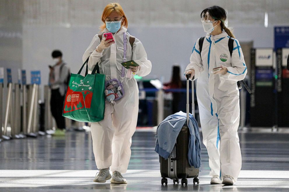 PHOTO:Alice Du and Haru Hu wear biohazard suits on their way to China at Tom Bradley terminal in Los Angeles, May 22, 2020.