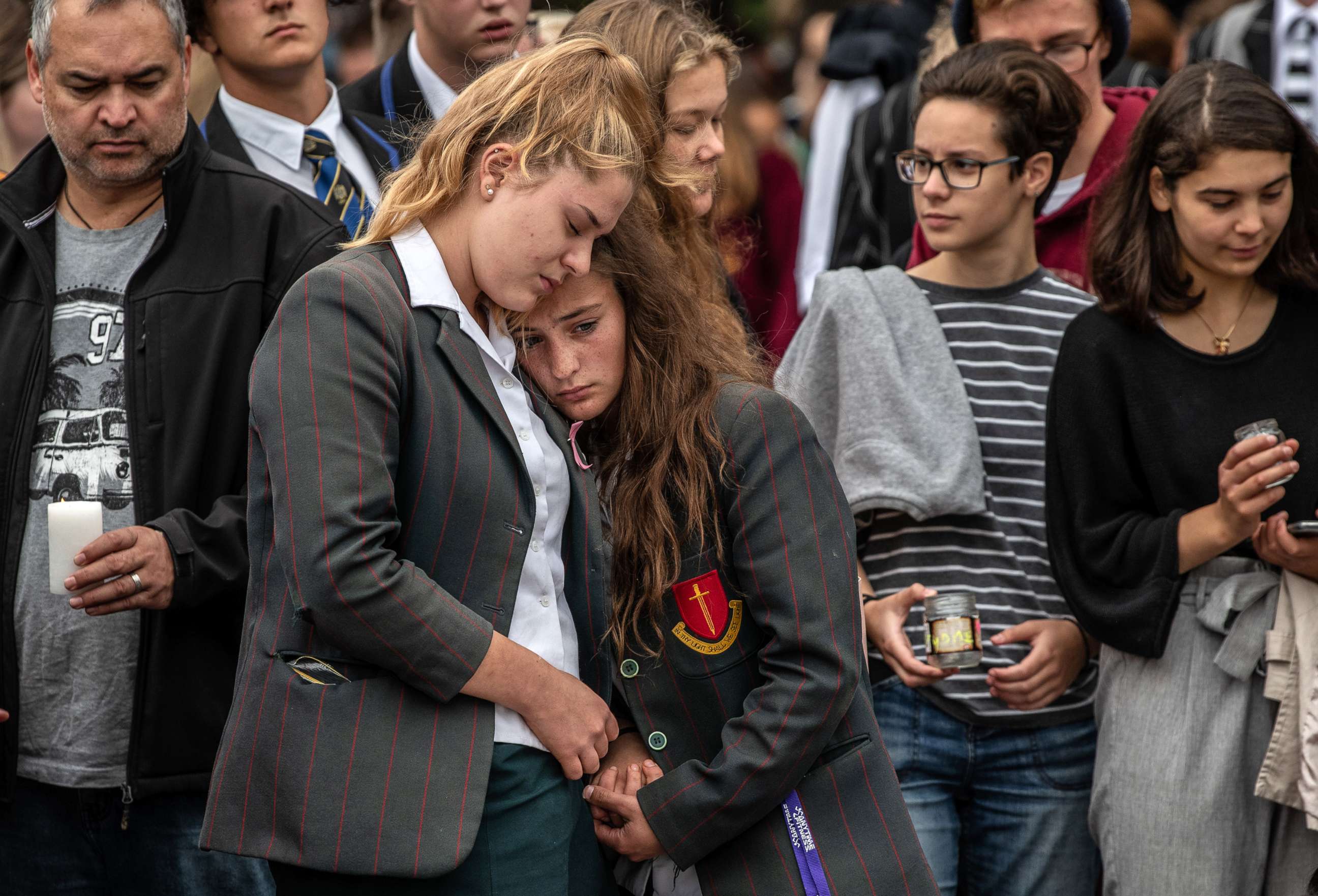 PHOTO: Schoolgirls comfort each other as they view flowers and tributes near Al Noor mosque, March 18, 2019 in Christchurch, New Zealand.