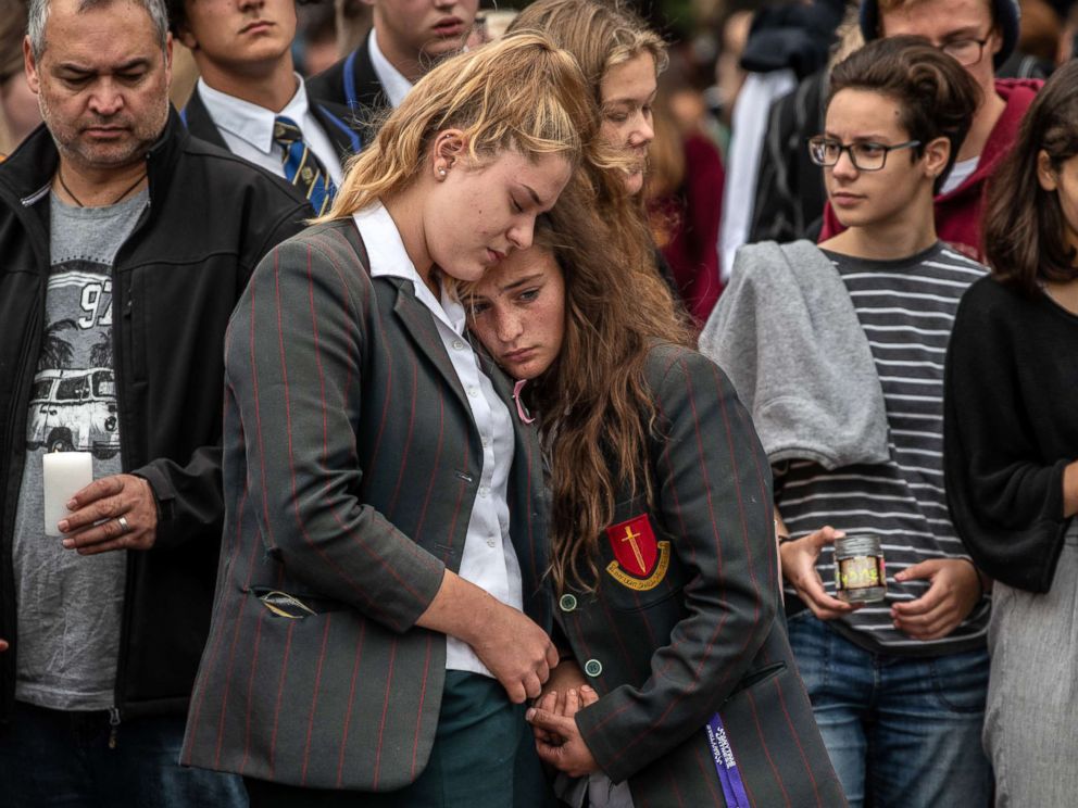 PHOTO: Schoolgirls comfort each other as they view flowers and tributes near Al Noor mosque, March 18, 2019 in Christchurch, New Zealand.