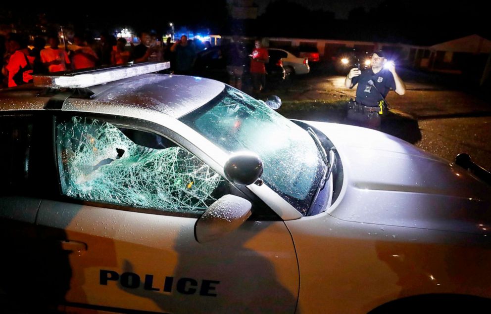 PHOTO: A Memphis police officer looks over a damaged squad car after protesters took to the streets of the Frayser community in anger against the shooting a youth by U.S. Marshals earlier in the, June 12, 2019, in Memphis, Tenn.