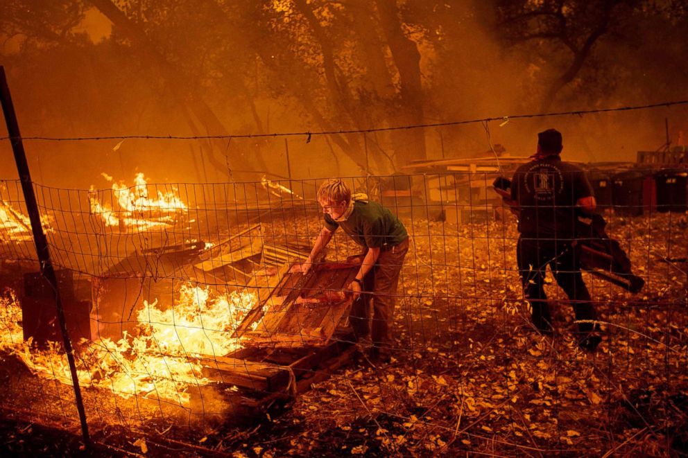 PHOTO: Alex Schenck moves flaming pallets while fighting to save his home as the Ranch Fire tears down New Long Valley Rd near Clearlake Oaks, Calif., Aug. 4, 2018.