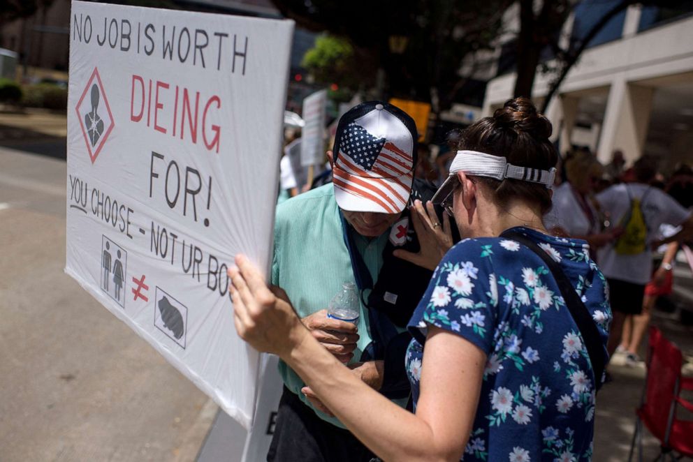 PHOTO: Anti-vaccine protesters hold signs outside of Houston Methodist Hospital in Houston, Texas, on June 26, 2021.